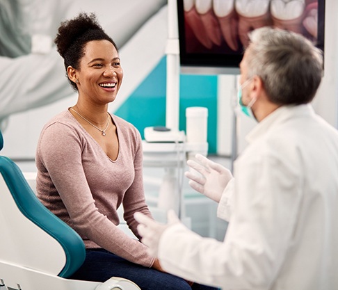 Smiling woman and dentist talking at biannual checkup