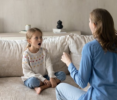Child performing mouth exercises during myofunctional therapy