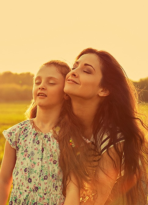 Mom and daughter taking a deep breath outdoors