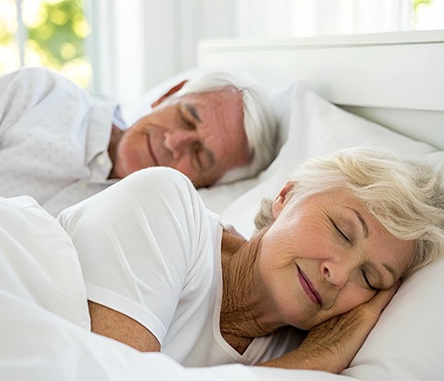 Older couple sleeping peacefully in bed