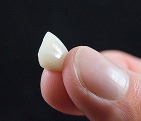Dental crown held in fingertips 