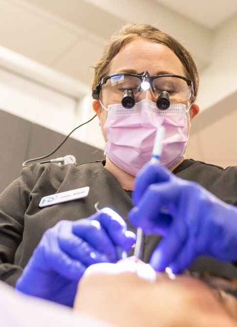 Man and woman smiling after replacing missing teeth