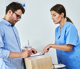 Patient filling out forms at dental office front desk