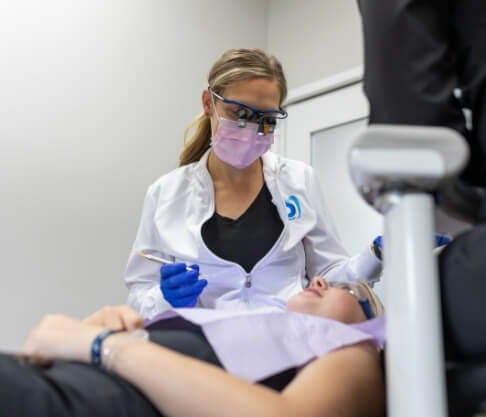 Woman looking at her smile during dental checkup and teeth cleaning visit