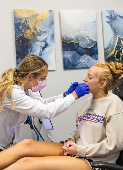 Woman in need of T M J therapy holding jaw in pain